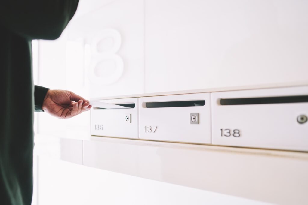 Courier inserting letter into postal box